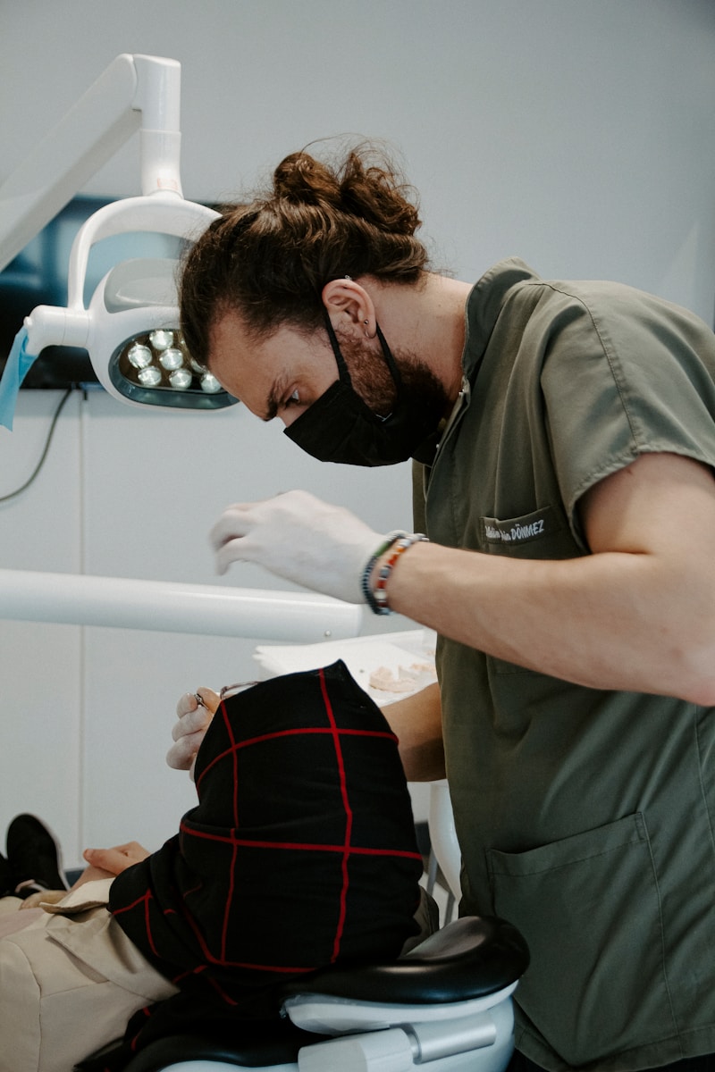 a man in a mask looking at a person in a stretcher